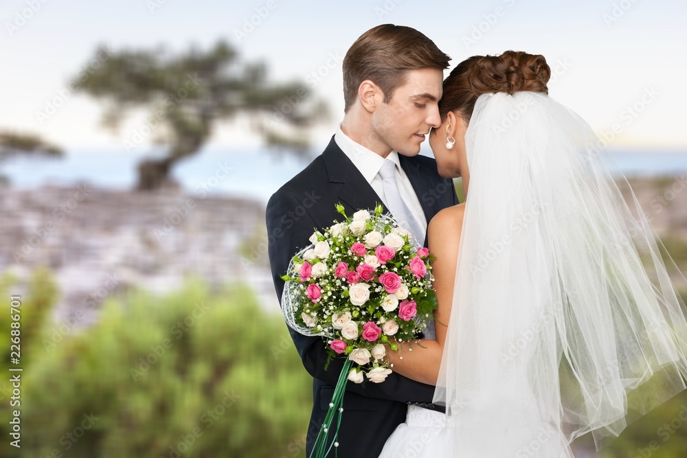 Bride and groom holding stylish bouquet during