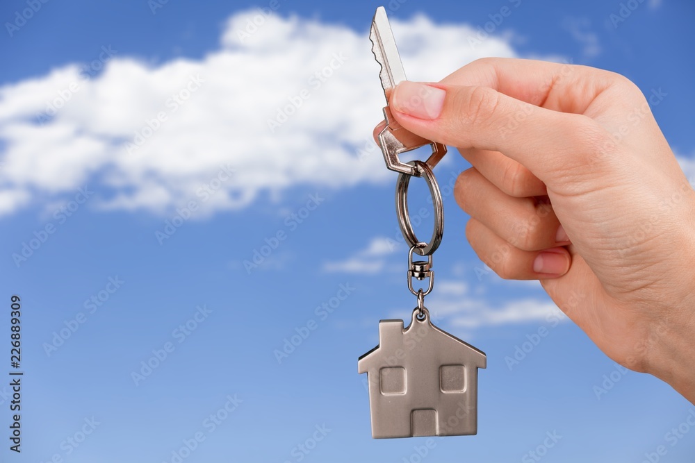 Hand Holding Metal House Key on white background