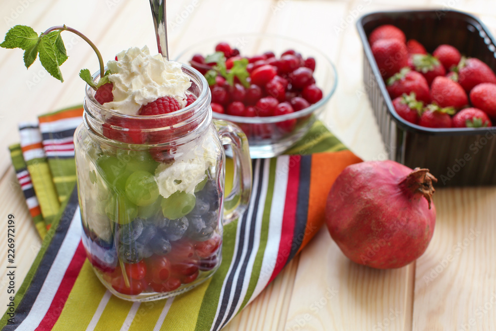 Delicious fruit salad in mason jar on wooden table