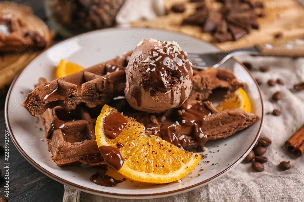 Delicious waffles with orange slices and ice cream on plate