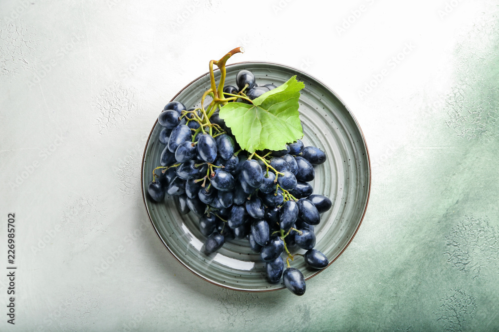 Plate with ripe sweet grapes on table, top view