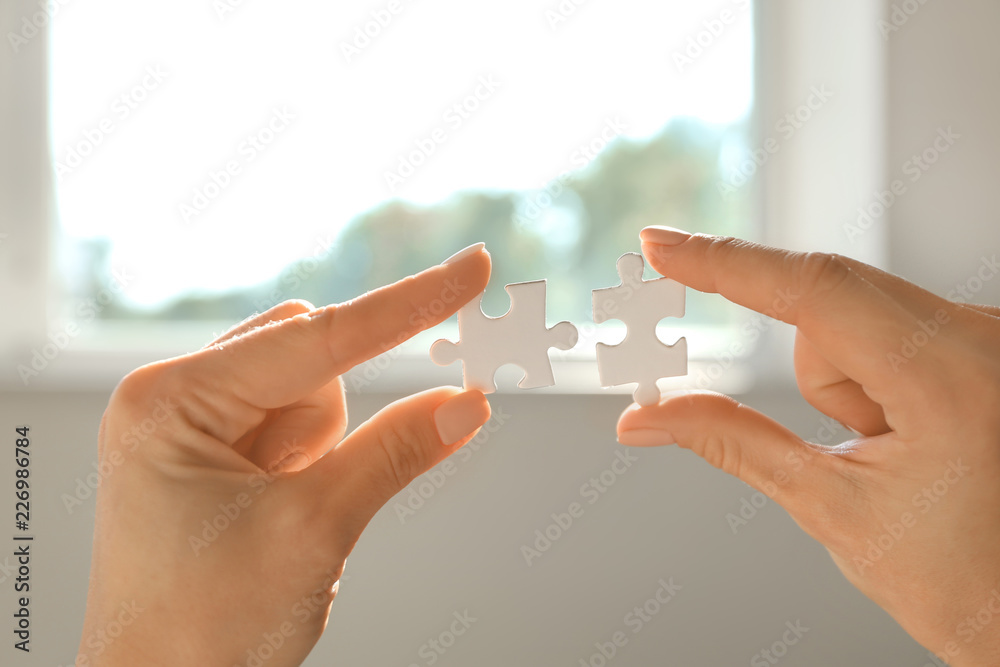 Woman with pieces of puzzle, closeup