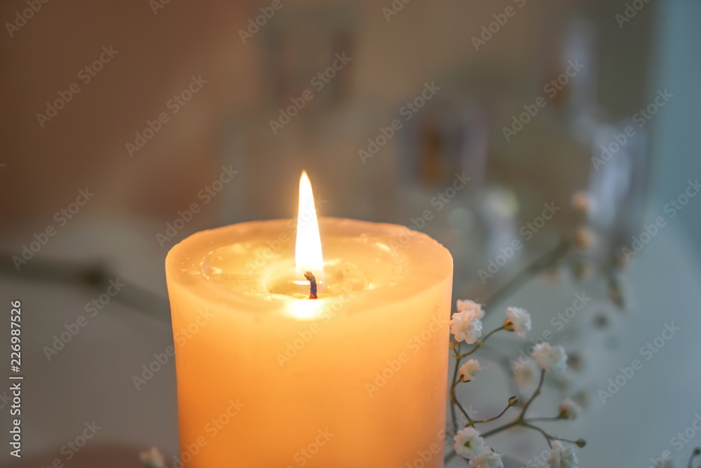 Beautiful burning candle with flowers on shelf, closeup