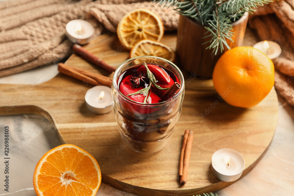 Glass of delicious mulled wine on wooden board