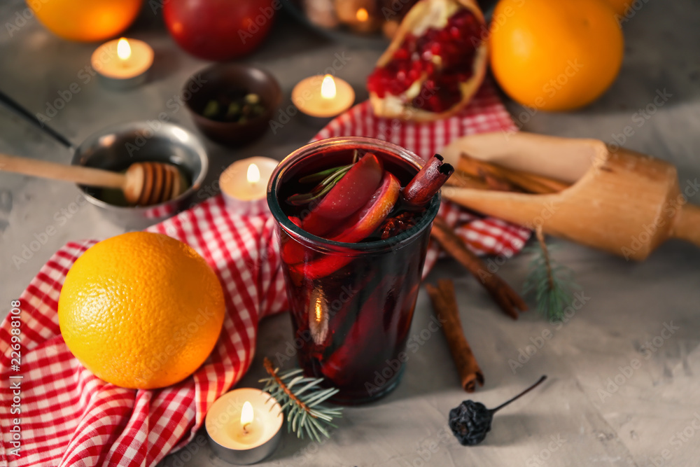 Glass of delicious mulled wine on grey table