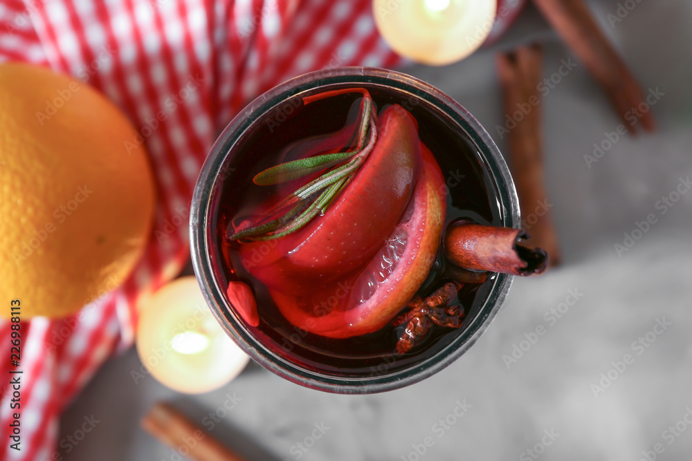 Glass of delicious mulled wine on grey table