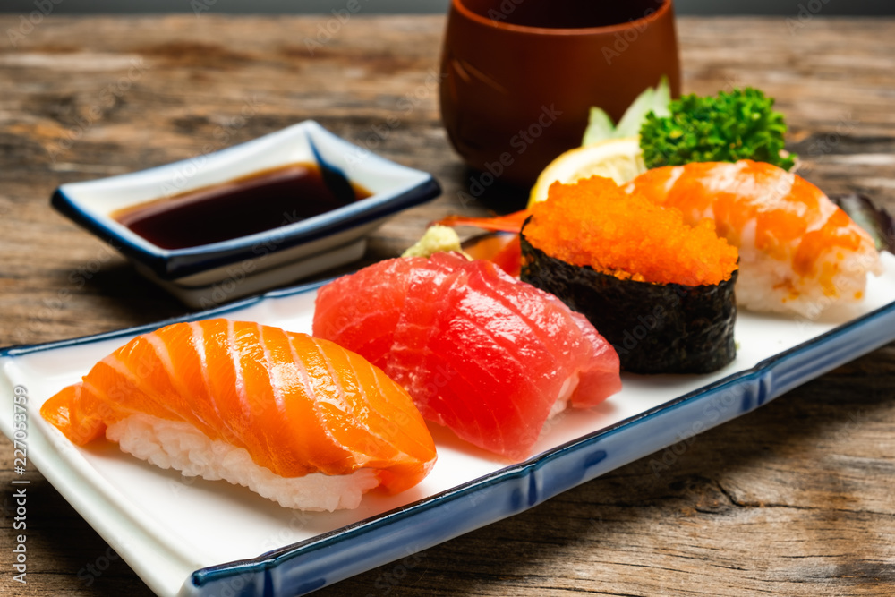 Sushi salmon & tuna sushi shrimp and wasabi on the white plate. on the wood table