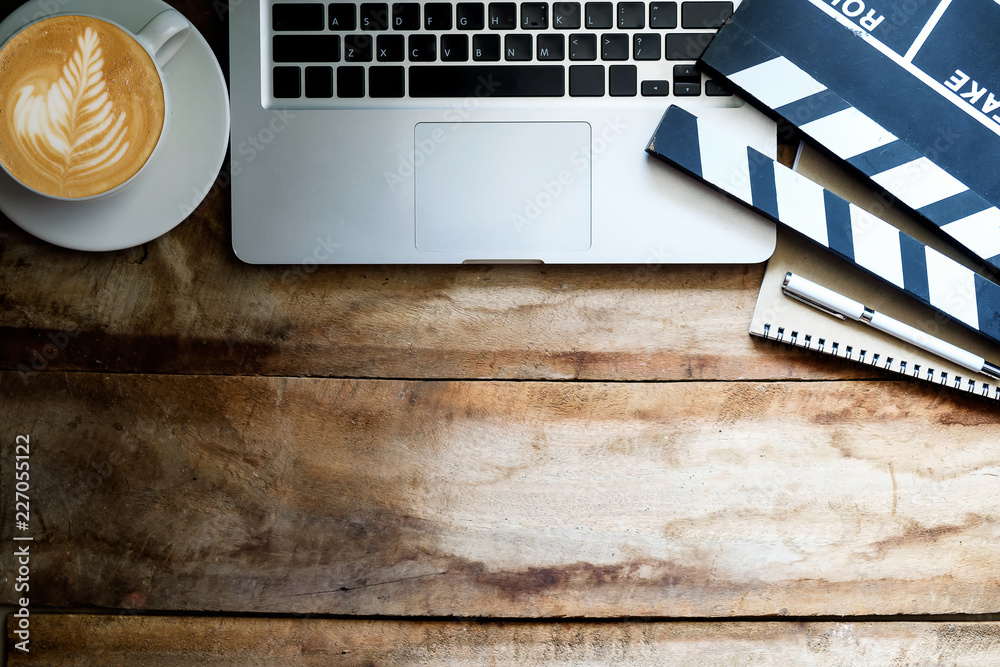 office stuff with Movie clapper, laptop, smartphone, tablet, coffee cup, pen, notepad and documents 