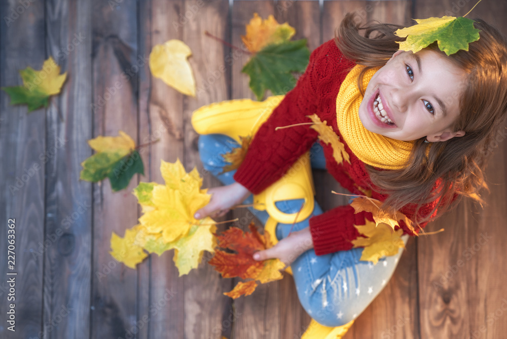 child playing with autumn leaves