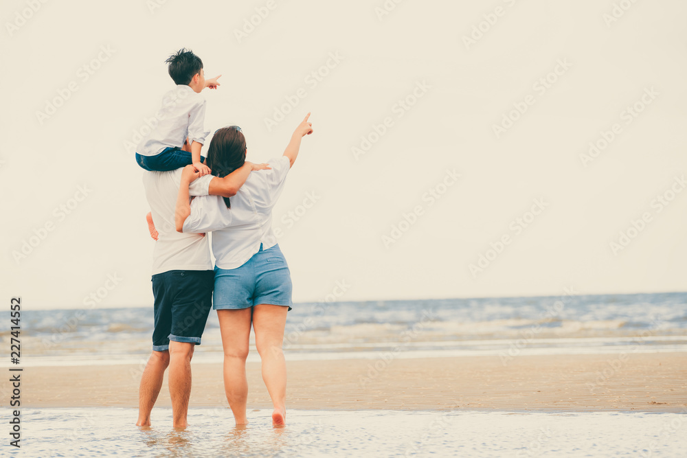 Happy family of father, mother and son goes vacation on a tropical sand beach in summer.