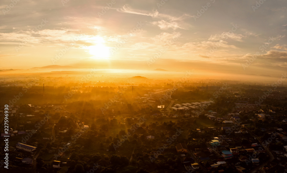 Aerial view of golden sunlight at sunrise with fog covered city town at the summer seasons.