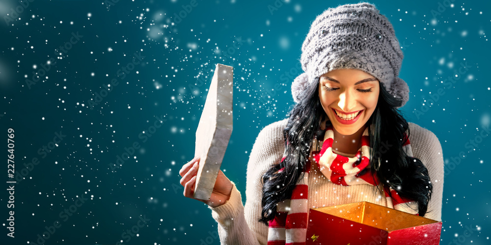 Happy young woman opening a Christmas present box