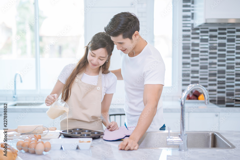 young Asian couple helping to make bakers