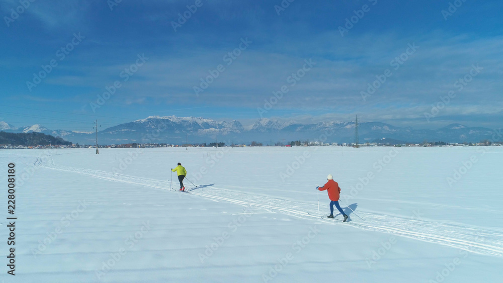 空中飞航：在阳光明媚的日子里飞越两名活跃的女性游客越野滑雪