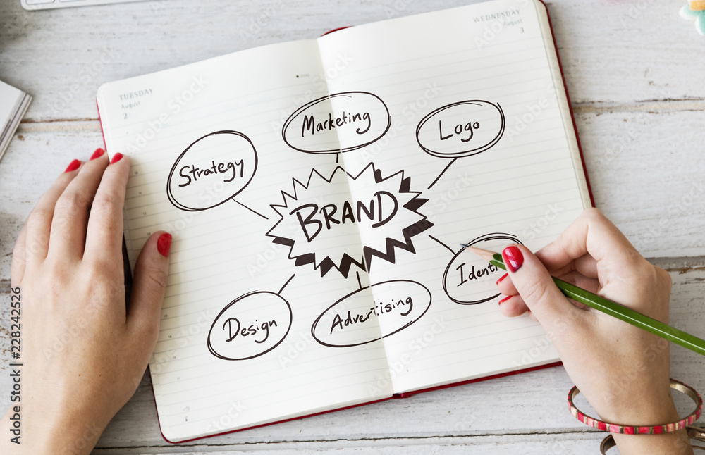 Young woman drawing brand in a notebook