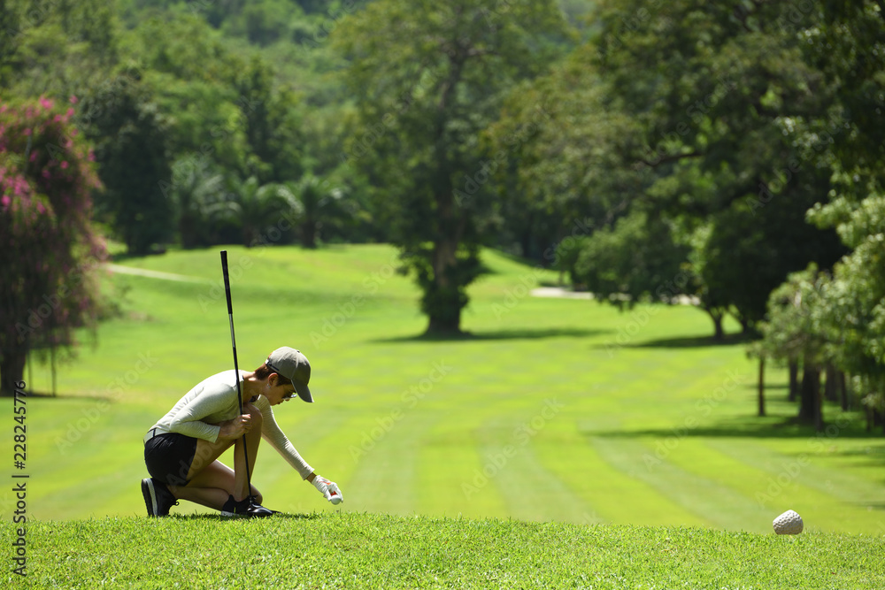 Asian woman playing golf on a beautiful natural golf course