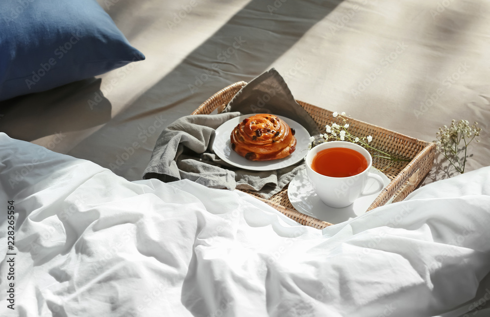 Wicker tray with delicious breakfast on bed