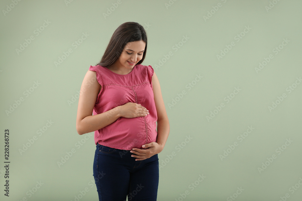 Beautiful pregnant woman on color background