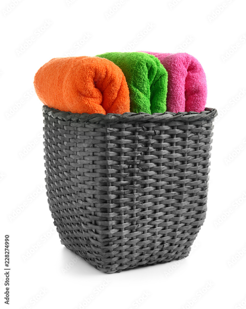 Wicker basket with fresh bright towels on white background