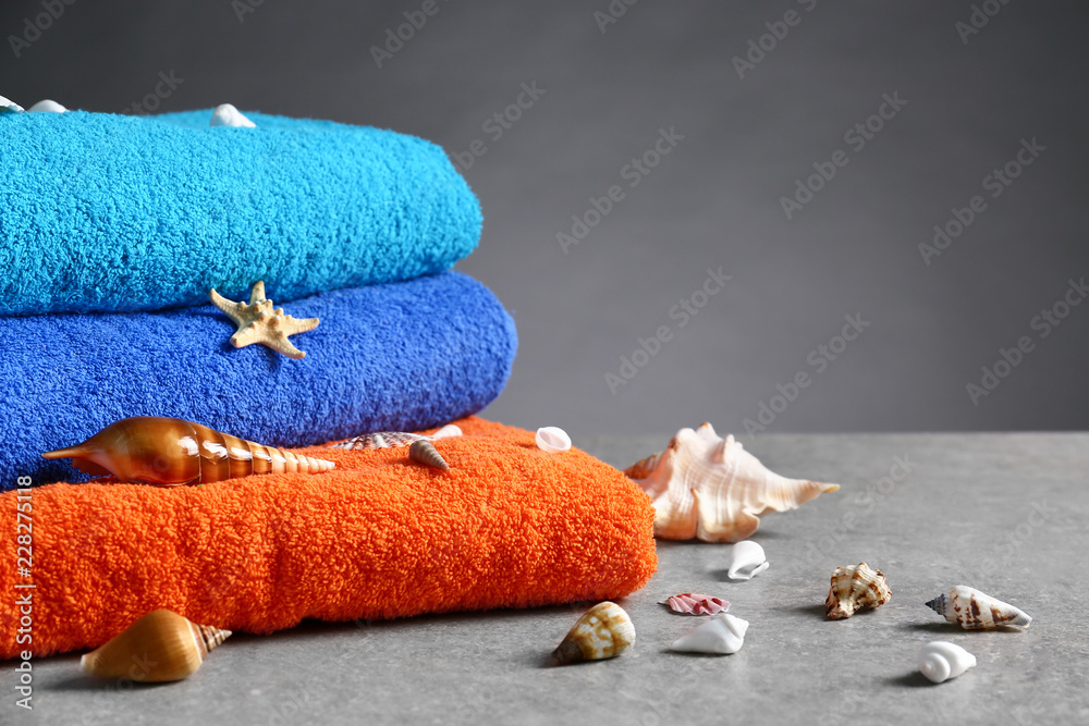 Tidy towels and seashells on grey table