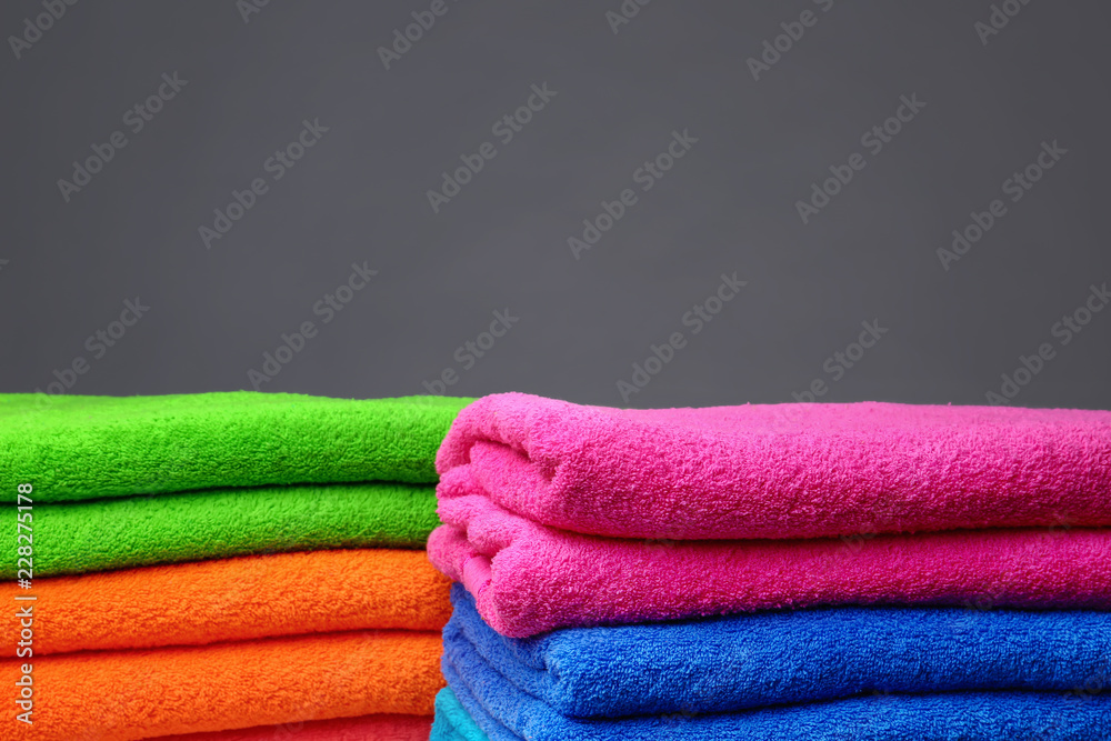 Stacks of soft color towels on grey background