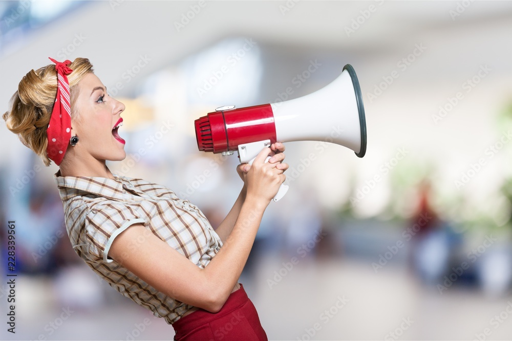 Portrait of woman holding megaphone, dressed in pin-up style