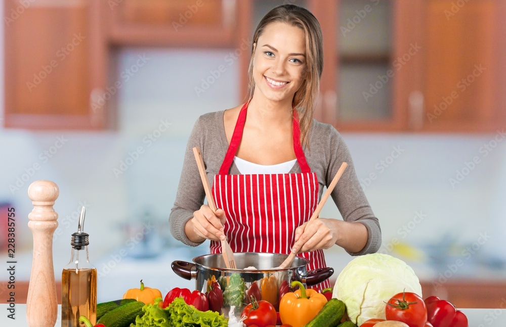 年轻漂亮女人在厨房做饭