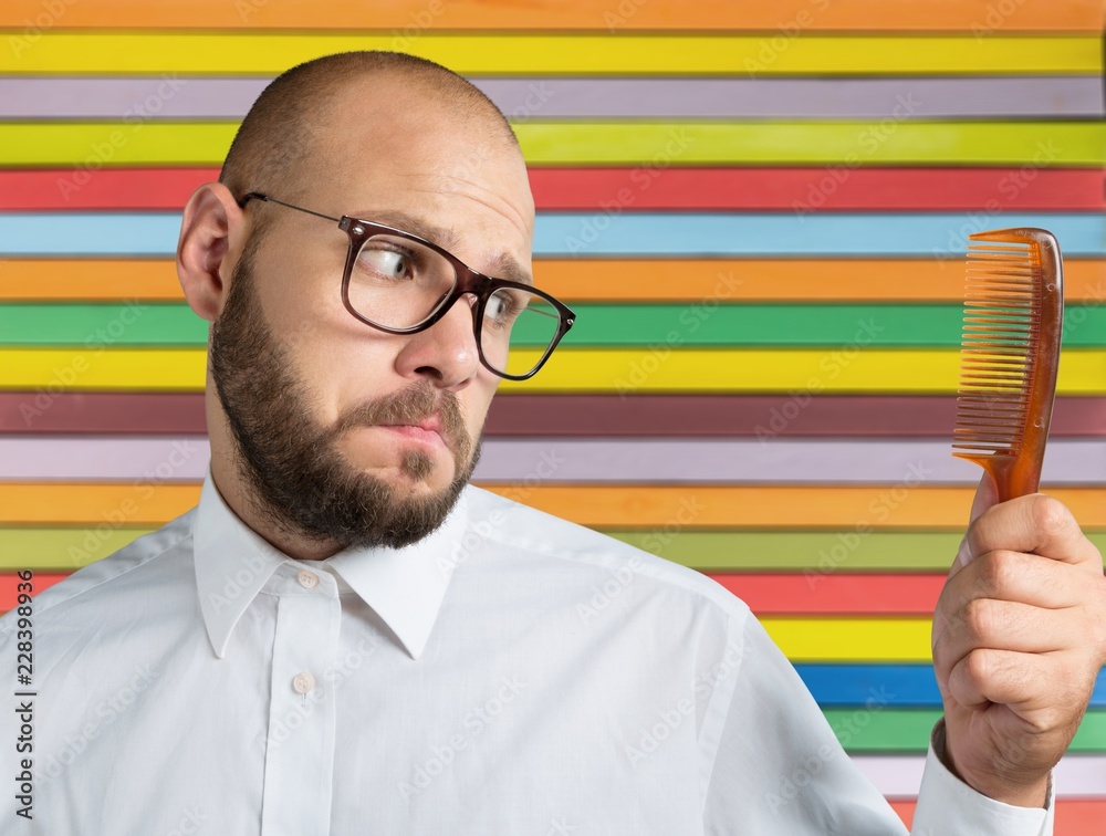 Adult bald  man hand holding comb