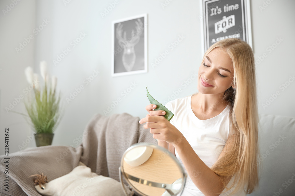 美丽的年轻女人在家里使用芦荟