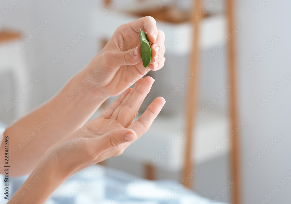 美丽的年轻女人在家里使用芦荟