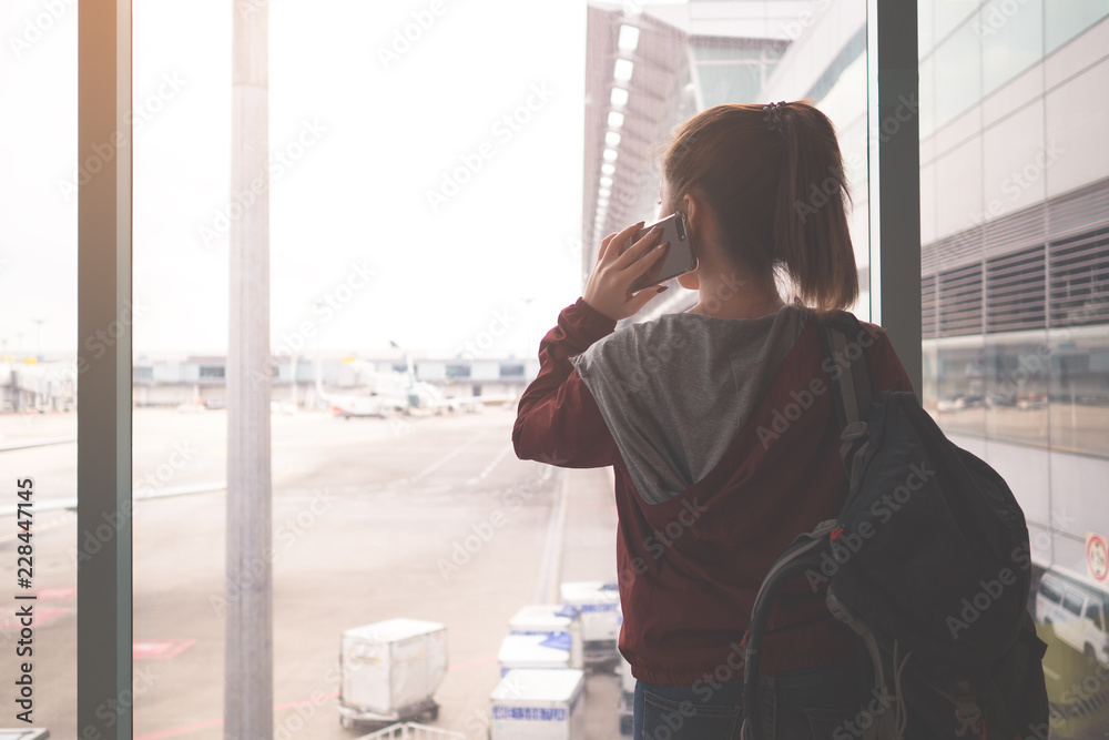 机场登机口背着双肩包的女旅行者。添加复古色调。