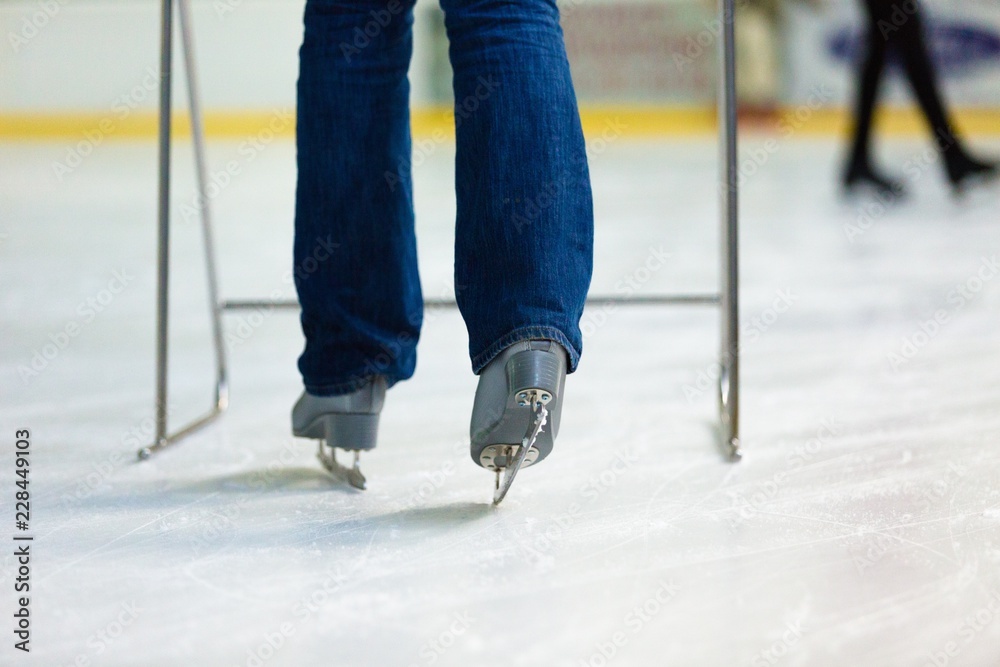 Close-up of Legs in Skates on Skating Rink