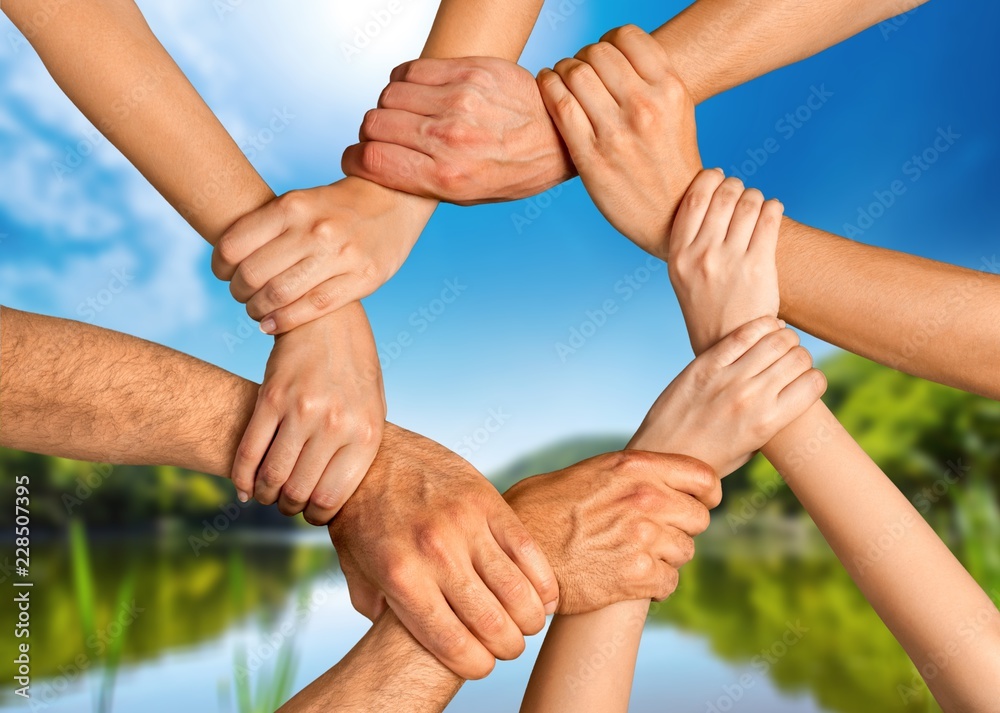 Group of people stacking hands together