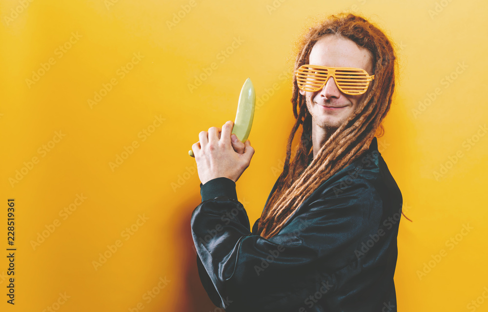 Funky fashion man with dreadlocks and painted quirky bananas