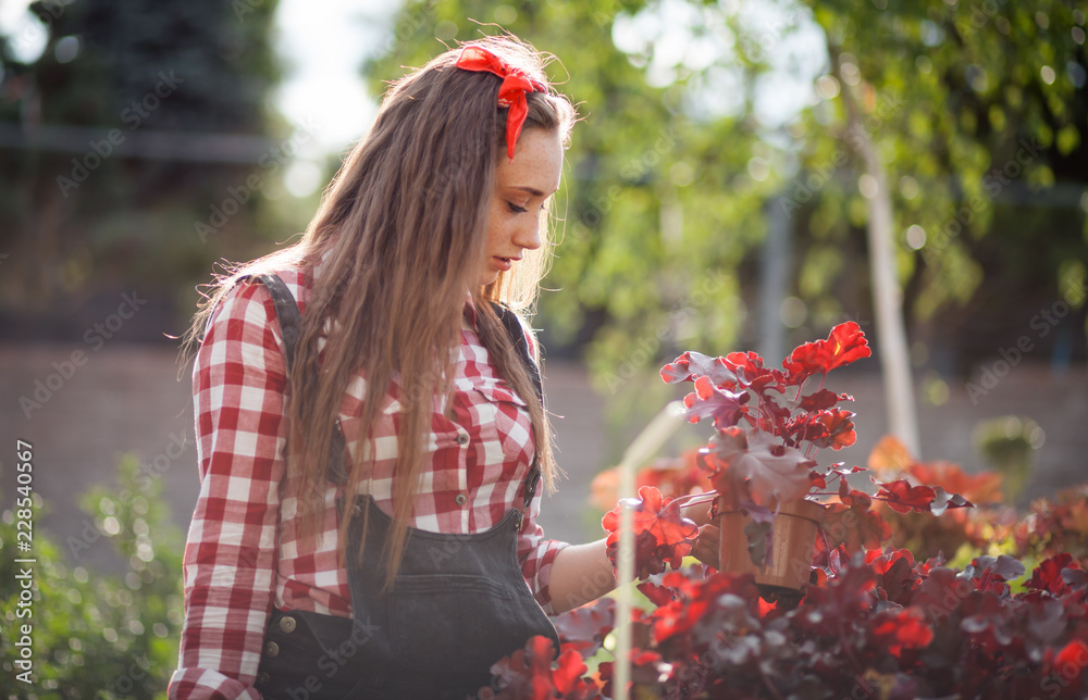 Young gardener woman choosing and buying potted plants in garden center