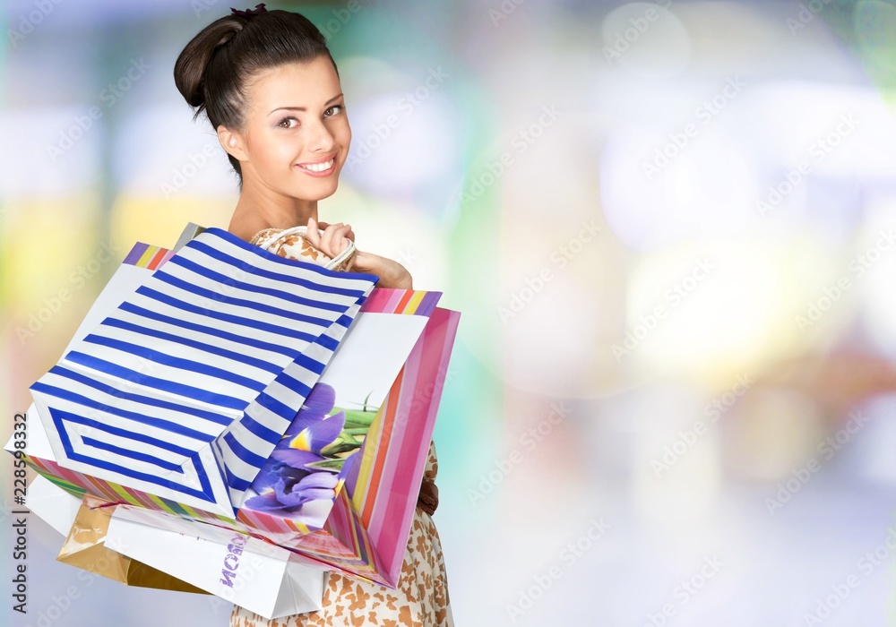 Young woman with shopping bags on  background