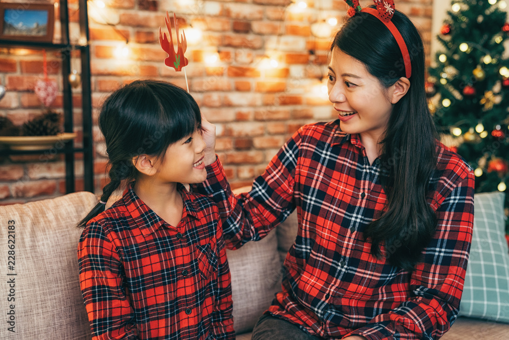 mother and cute girl having fun on christmas eve