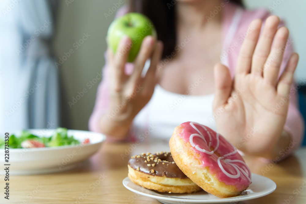 年轻女孩拒绝垃圾食品或甜甜圈等不健康食品，选择健康食品如
1880869001,宠物猫