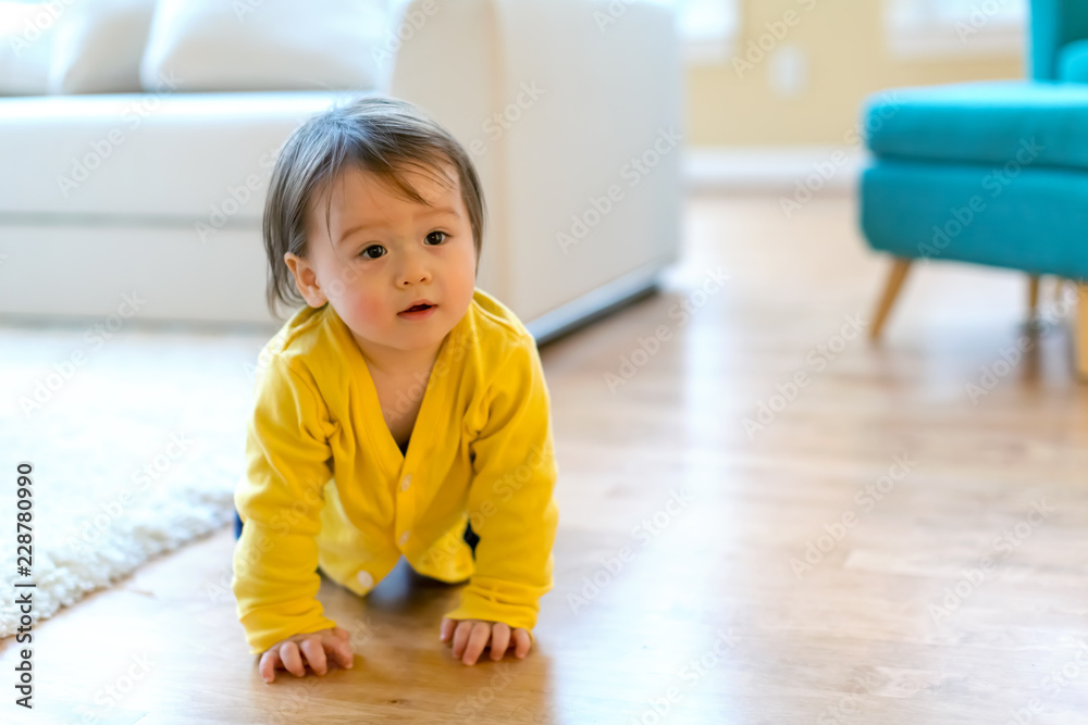 穿着黄色衣服的幼童在家里玩耍