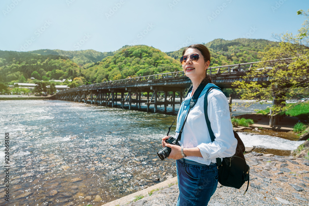 优雅的旅行者站在干净的河边