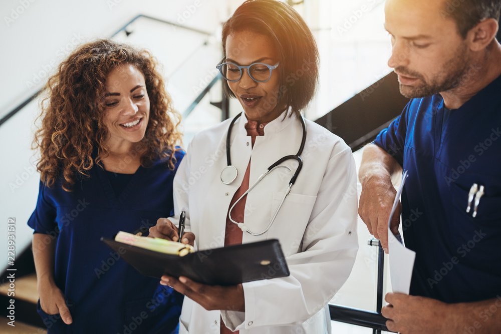 Smiling group of diverse doctors talking together in a hospital