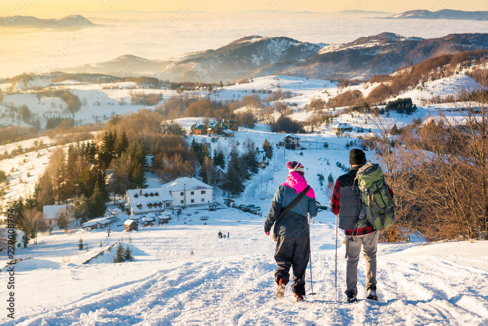 日落时分，情侣走下雪山