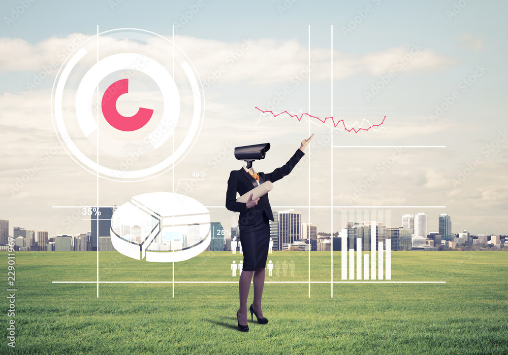 Camera headed woman standing on green grass against modern citys