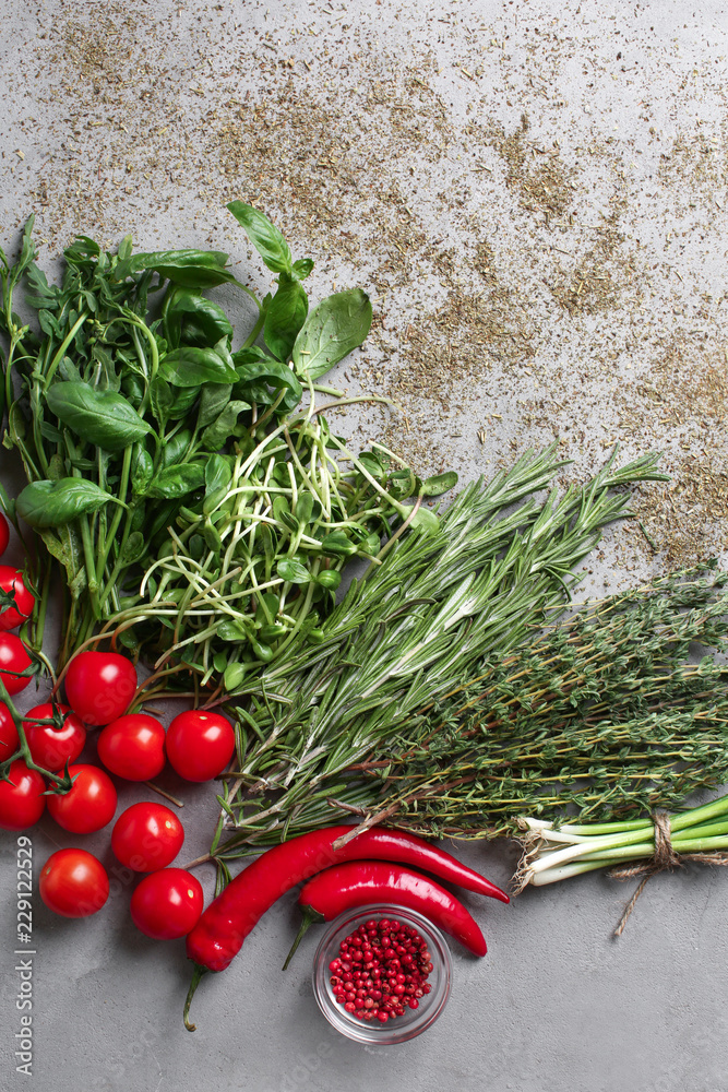 Tomatoes, spices and fresh herbs on grey background, top view