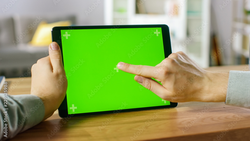 Close-up of Man Using Hand Gestures on Green Mock-up Screen Digital Tablet Computer in Landscape Mod