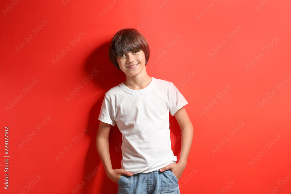 Smiling little boy in t-shirt on color background