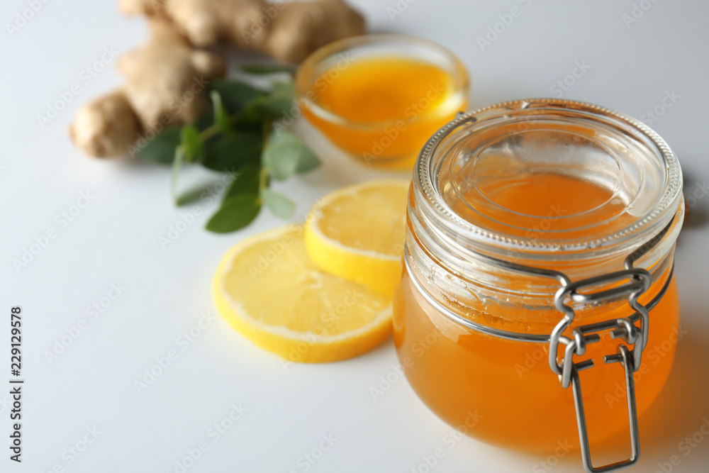 Jar with honey on light background, closeup