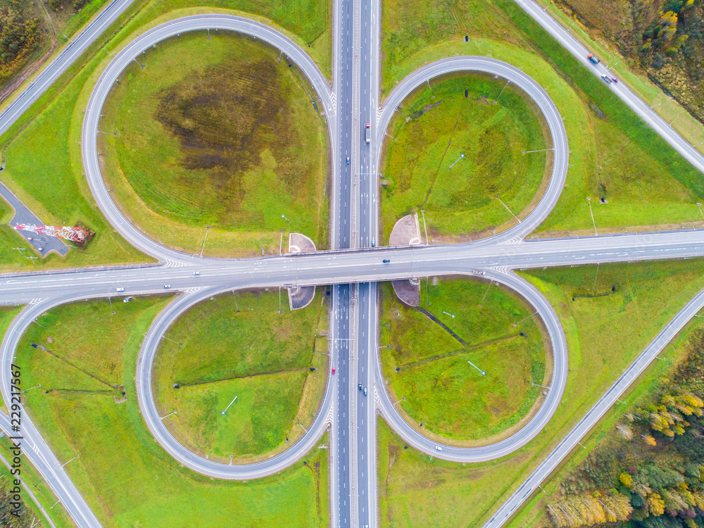 Aerial view of highway in city. Cars crossing interchange overpass. Highway interchange with traffic