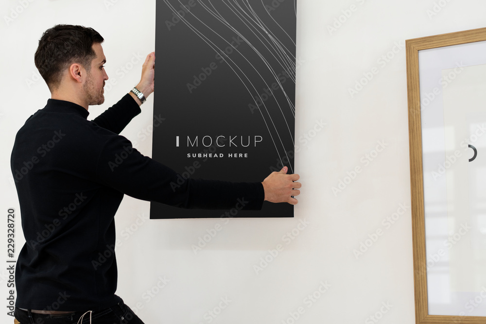 Curator hanging an art piece mockup on the wall in a gallery