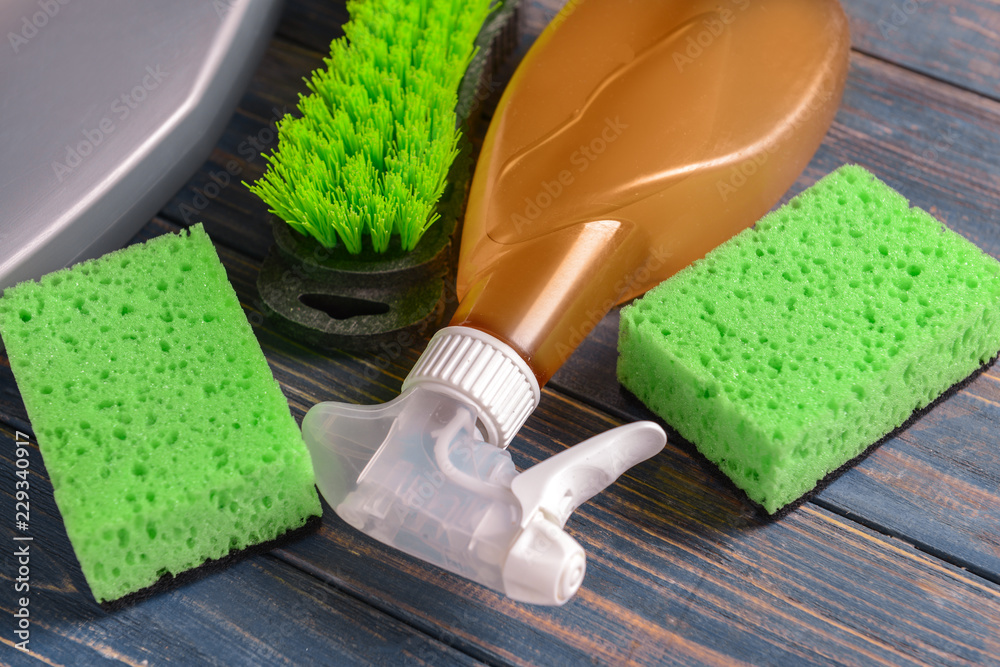 Cleaning supplies on color wooden background